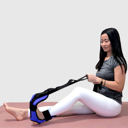 Woman using a blue foot and calf stretcher with yoga straps to relieve plantar fasciitis, Achilles tendonitis, tight calves, and hamstring tension—versatile foot rocker stretcher and calf stretch device for improved flexibility and recovery.